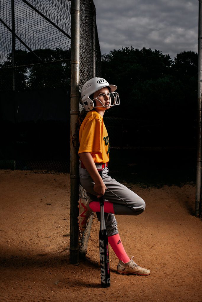 A young boy in yellow shirt holding baseball bat.