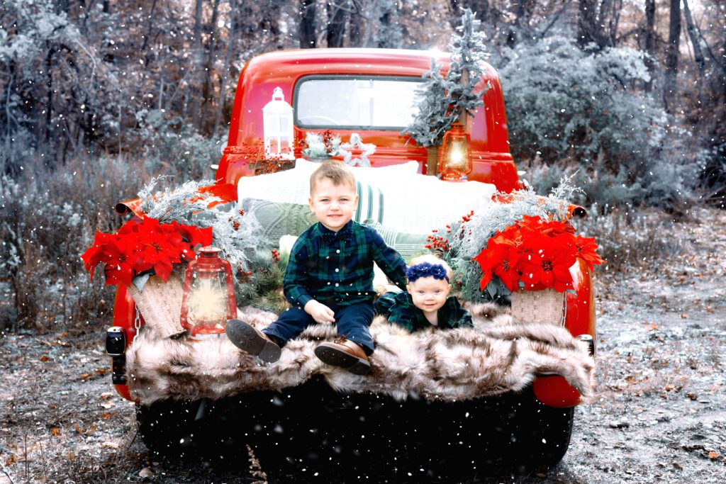 Children's Christmas photo shoot on back of Red pickup truck with snow